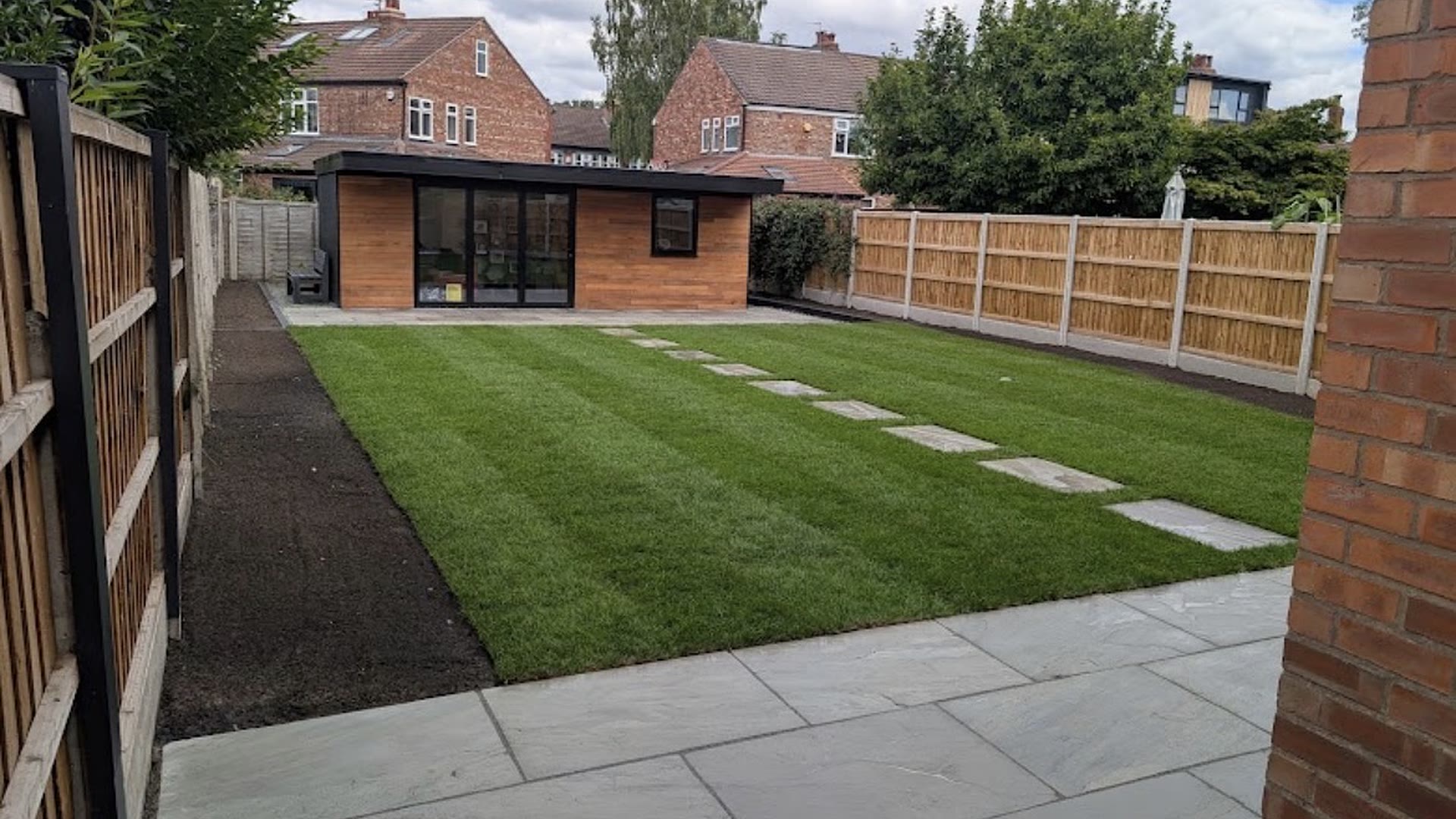 Newly laid Indian stone patio, striped lawn and garden room in a Sale back garden